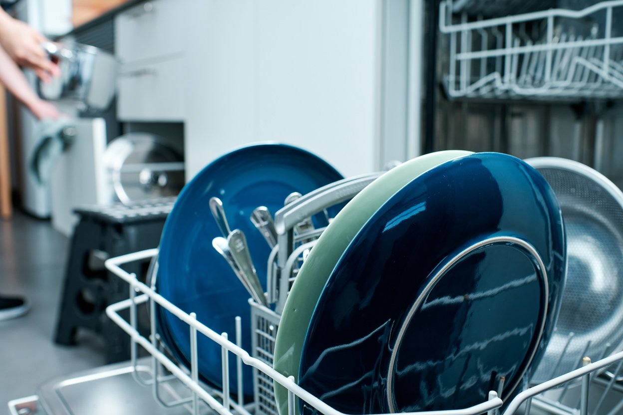 Diswasher Closeup with Woman Organizing Kitchen Objects